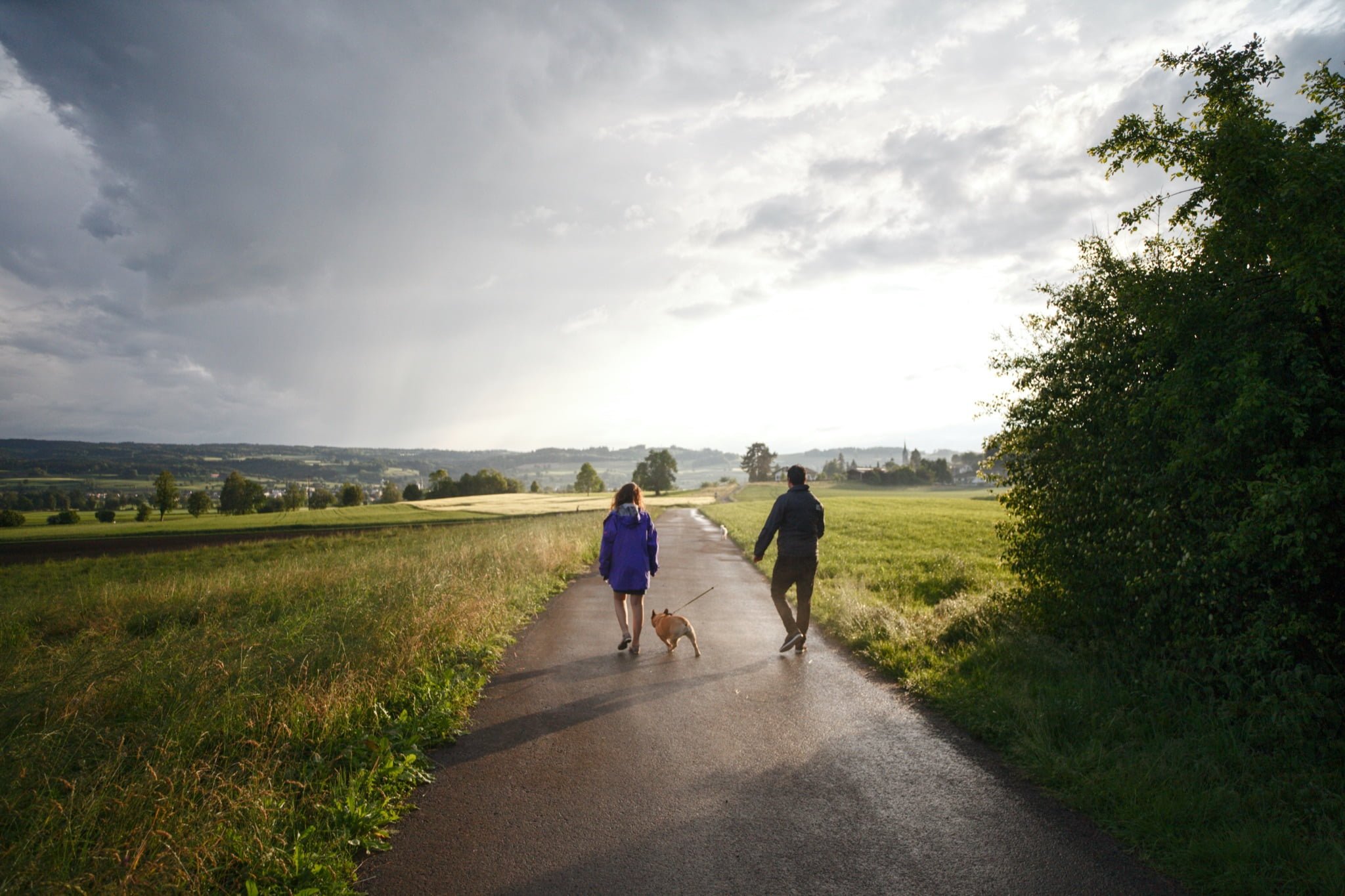 man and women walking their dog as fun and exciting activities 