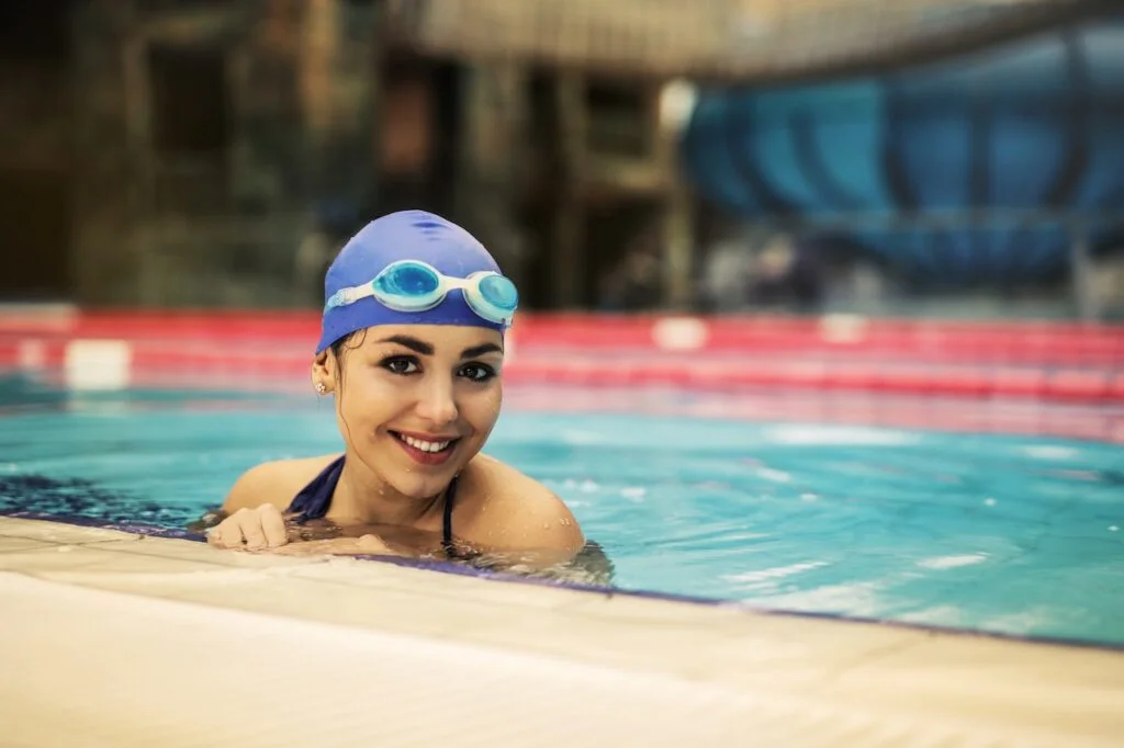 Woman swimming in a pool with swimmin glasses and headcap